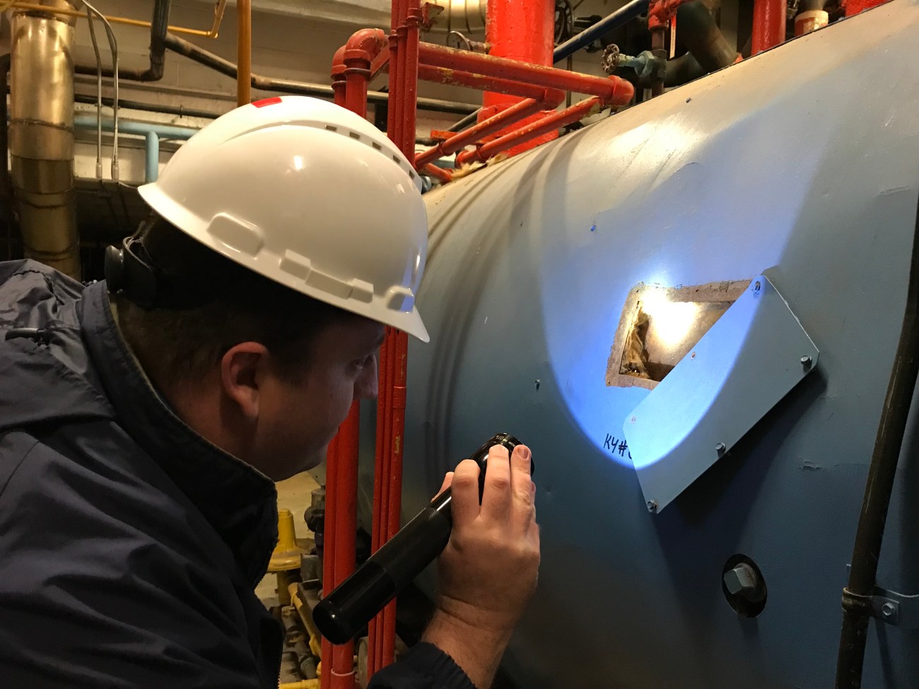 Inspecting boiler insulation. Photo by Roberta Burnes.