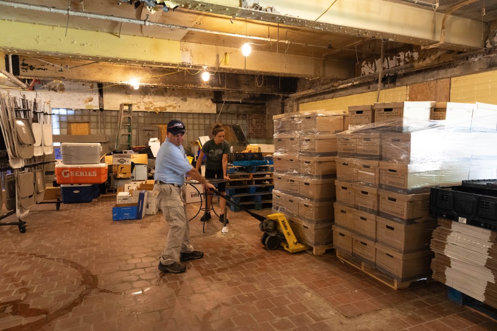 Recycling Technician Jason Craig wheels a pallet of bankers boxes into FoodChain, a non-profit organization in Lexington that uses on boxes to deliver food to households in need. 