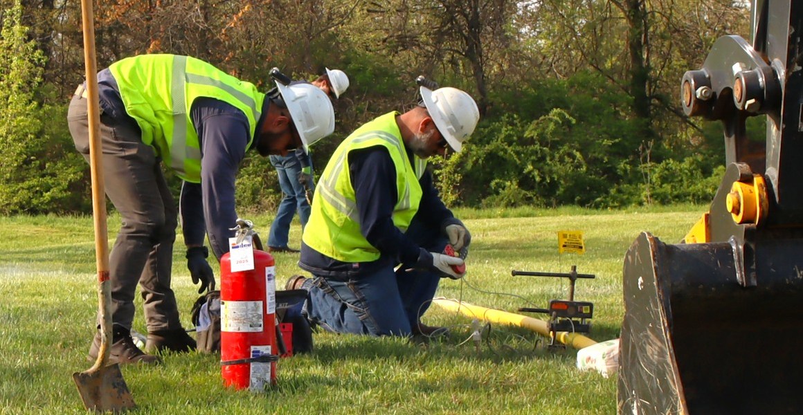 Line workers crimp a pipeline.