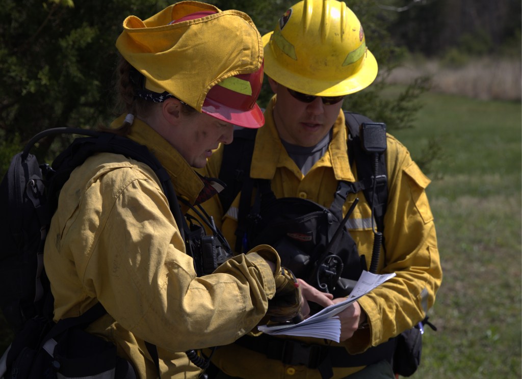 Biologist Heidi Braunreiter and Burn Boss Zach Beyer discuss sections of the 8-acre nature preserve during a prescribed burn