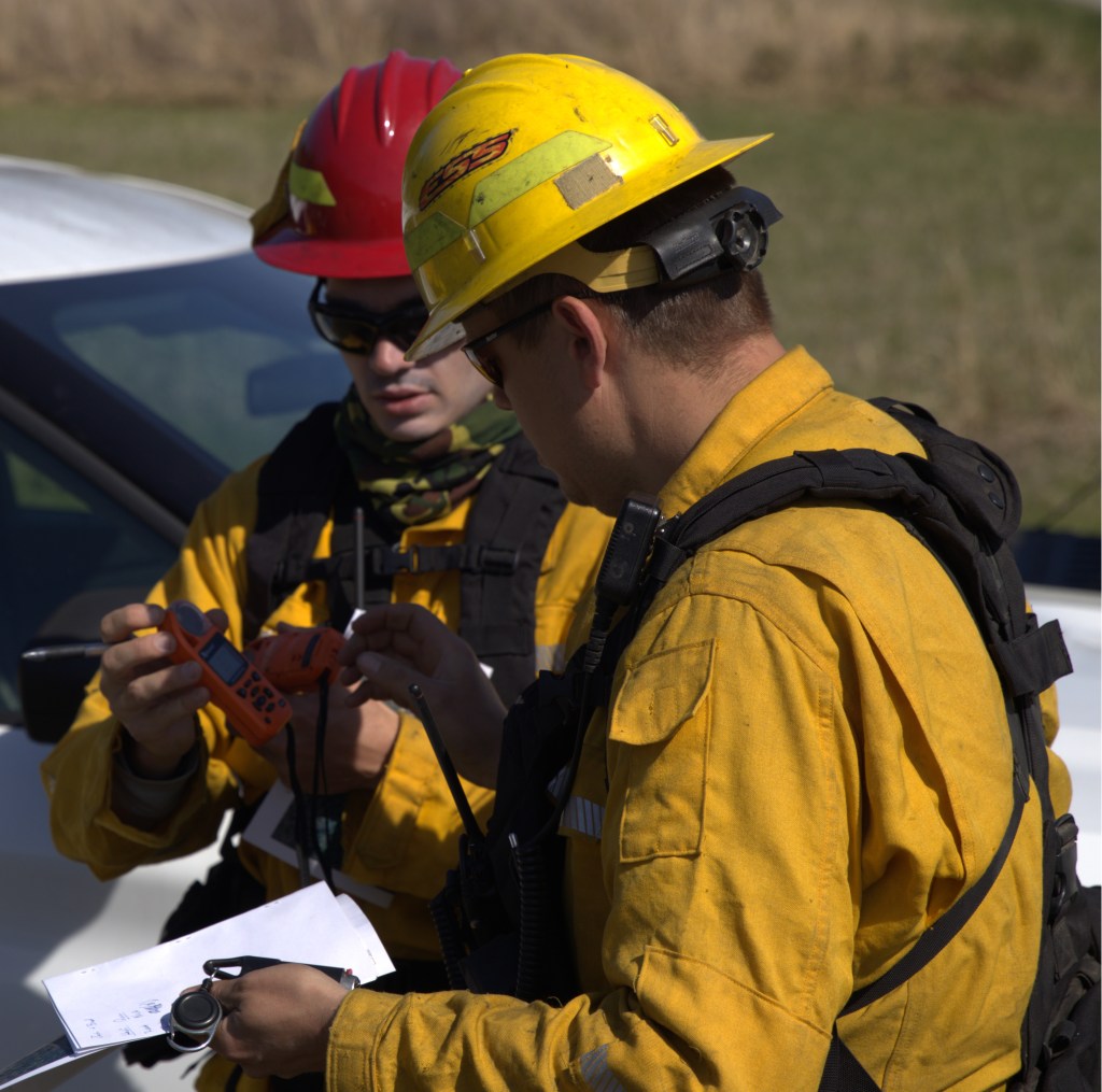 Beyer and  Robert Chambliss look at wind and weather report for the burn. Photo by Brad Bowman 
